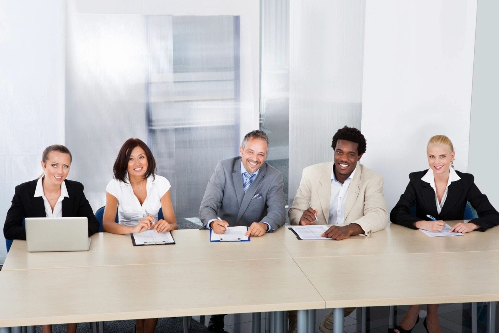 A group of people sitting at a table with papers.