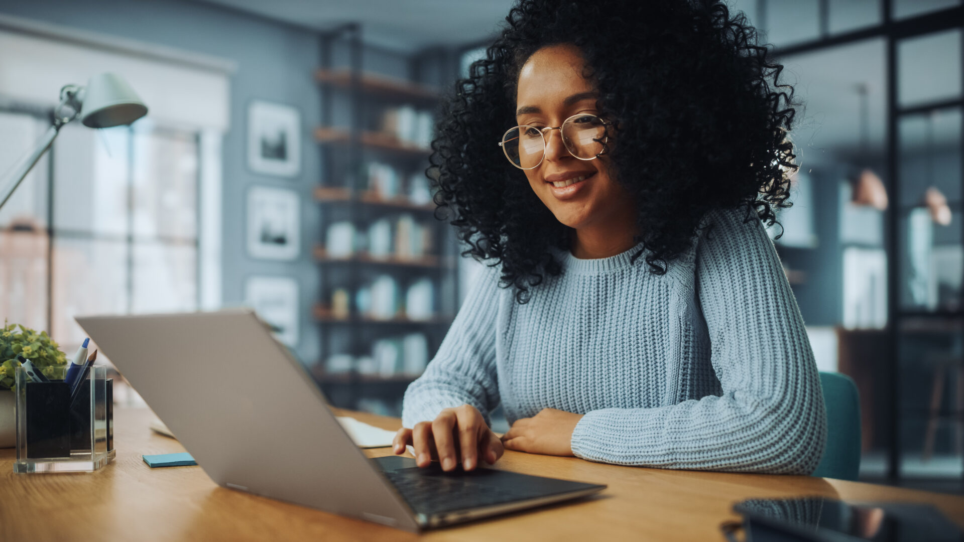 A woman sitting at a table with her laptop.